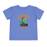 The Monster Truck Rex T-Shirt 🛻🦕 – Toddler Boys Tee features a blue Bella+Canvas shirt with a cartoon green dinosaur in a monster truck and bold orange MONSTER TRUCK REX text—perfect for any toddler dino fan.