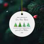 Personalized round Christmas ornament celebrating the first Christmas in a new home, featuring festive Christmas trees and custom names with an address.