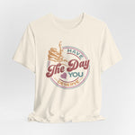 The Have The Day You Deserve Kindness Gift: Motivational Skeleton T-Shirt for Positive Vibes is a cream unisex 100% Airlume cotton tee with a skeleton hand thumbs-up and retro text: Have the day you deserve, plus a heart detail.