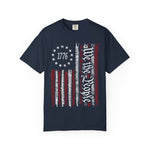 The We The People Distressed Flag Tee – Patriotic Comfort Colors 1717 Unisex Shirt features a navy blue, vintage American flag with 1776 in stars and We the People script on soft U.S. cotton.
