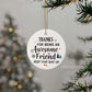 Round white Christmas ornament with a humorous appreciation message for an awesome friend, decorated with festive icons and hung on a holiday tree.