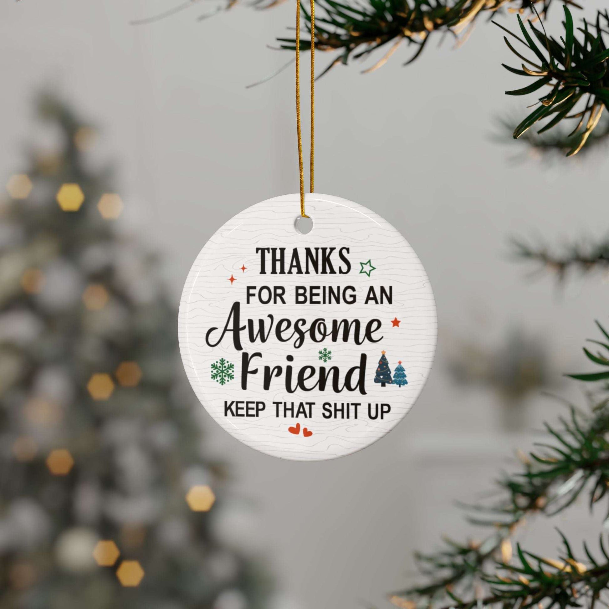 Round white Christmas ornament with a humorous appreciation message for an awesome friend, decorated with festive icons and hung on a holiday tree.