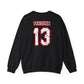 The Voorhees 13 Unisex Heavy Blend Crewneck Sweatshirt sports VOORHEES and the number 13 in bold, scratched white and red letters on the back, offering a casual, sporty look ideal for horror enthusiasts.