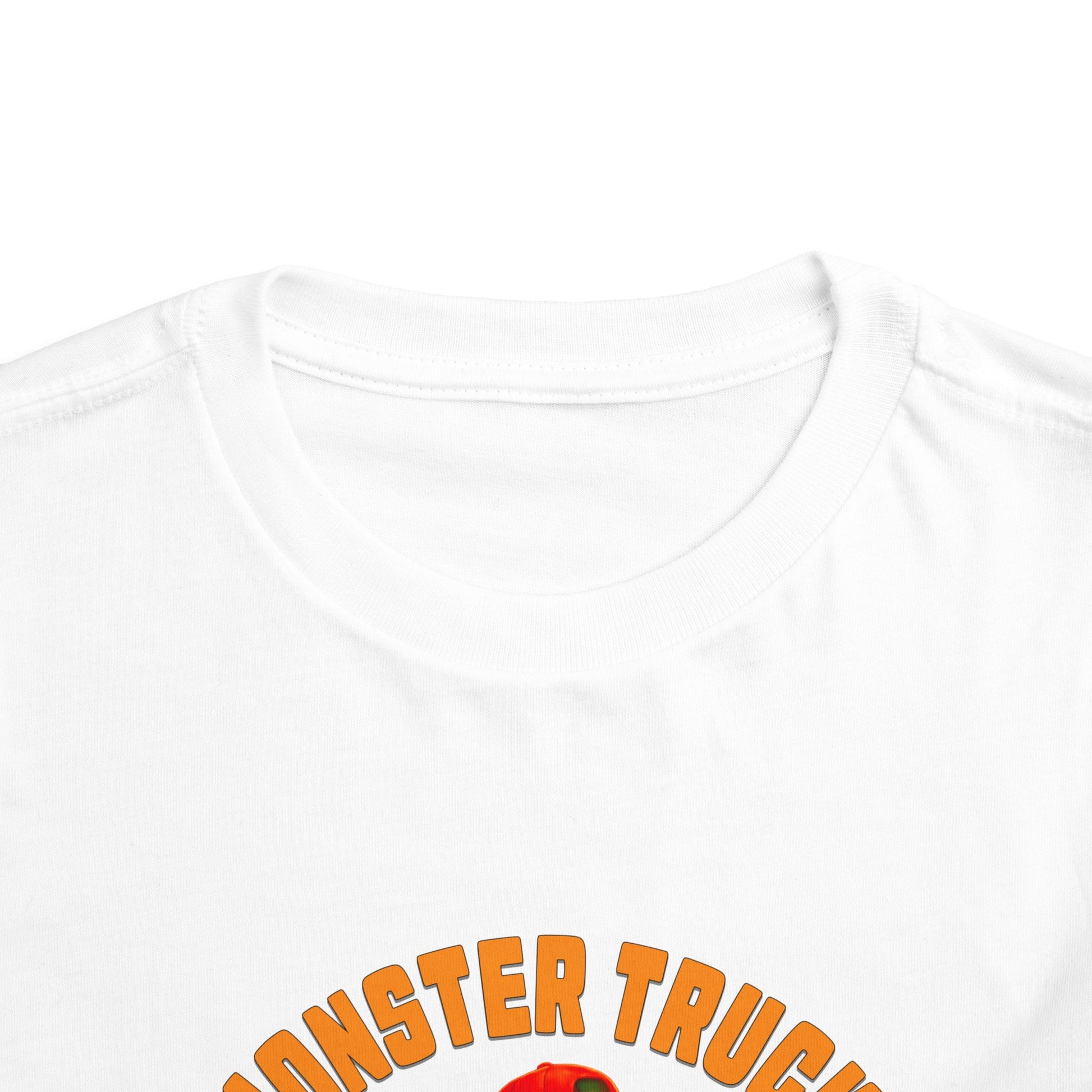 Close-up of the white Monster Truck Rex T-Shirt 🛻🦕 – Toddler Boys Tee showing MONSTER TRUCK in orange text on the neckline and shoulders—perfect for little fans of monster trucks and dinos!.