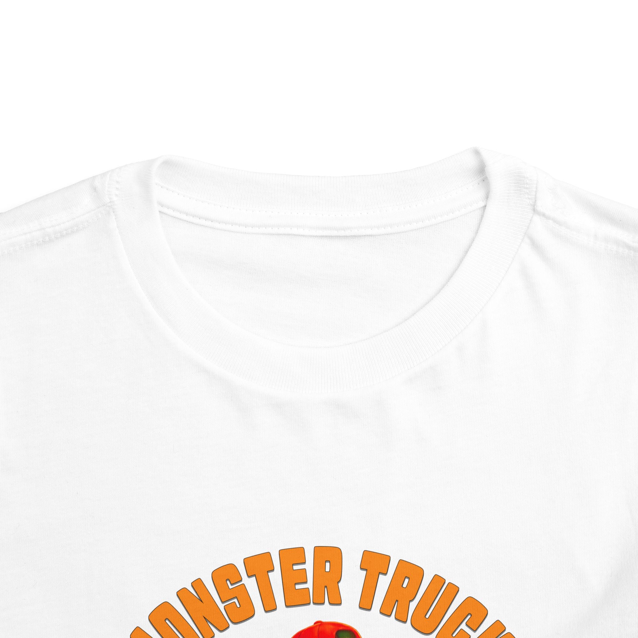 Close-up of the white Monster Truck Rex T-Shirt 🛻🦕 – Toddler Boys Tee showing MONSTER TRUCK in orange text on the neckline and shoulders—perfect for little fans of monster trucks and dinos!.