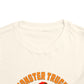 A close-up of the Monster Truck Rex T-Shirt 🛻🦕 – Toddler Boys Tee shows bold orange “MONSTER TRUCK” text. The Bella+Canvas shirt is displayed flat against a white background.