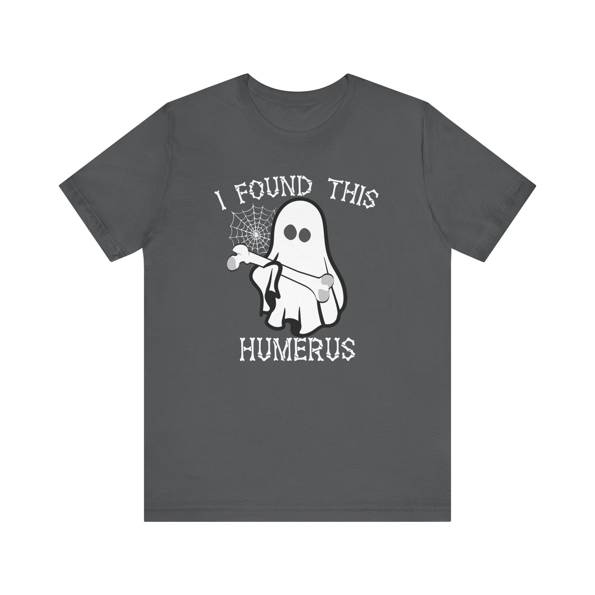 The I Found This Humerus - Funny Halloween Ghost T-Shirt is a dark gray tee with a playful ghost holding a bone and spider web, plus white lettering saying I FOUND THIS HUMERUS for extra spooky fun.