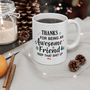 White ceramic mug with a humorous message thanking an awesome friend, decorated with festive elements like snowflakes and trees.