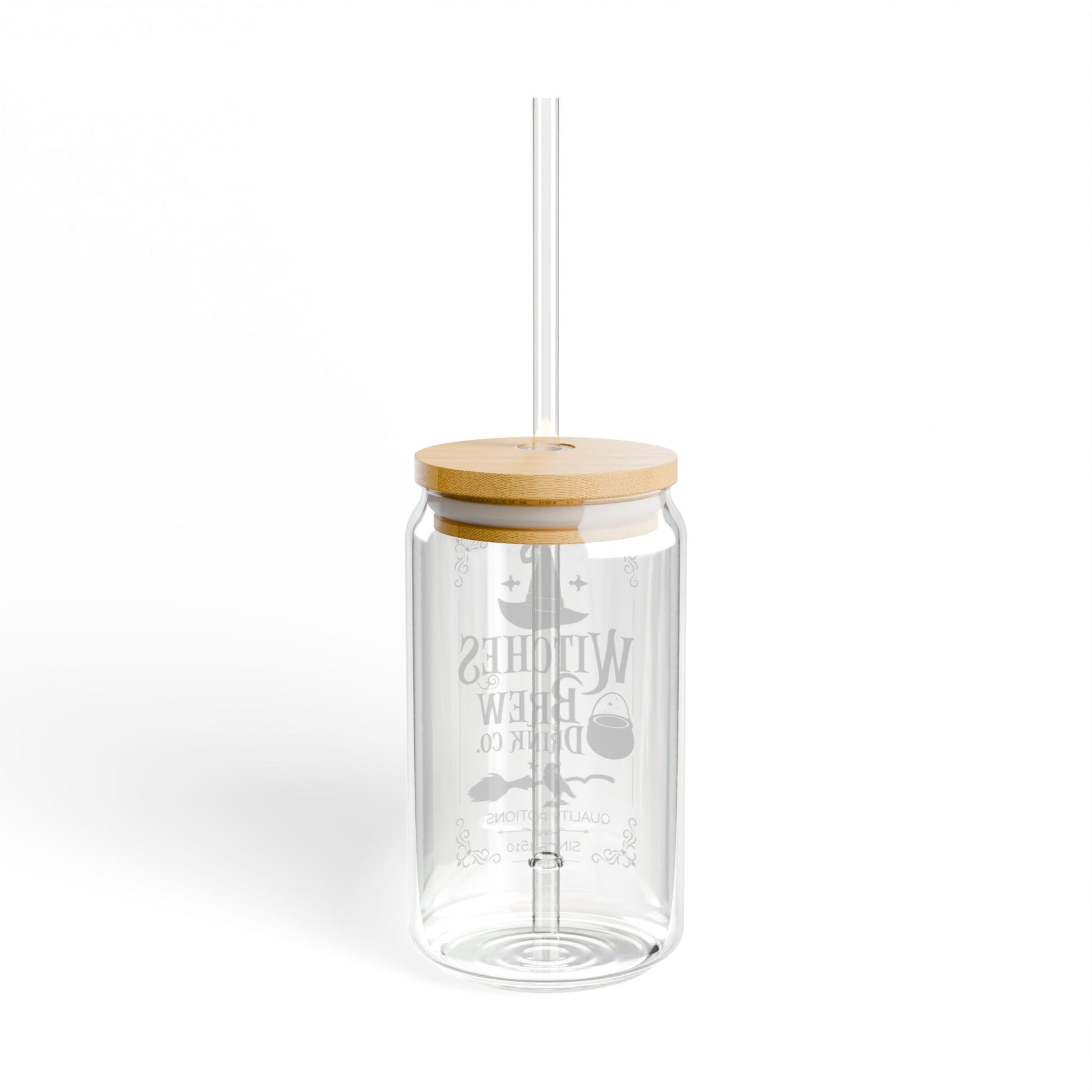 The Witches Brew Drink Co. 16oz Halloween Sipper Glass features a bamboo lid, straw, and whimsical illustrations on clear glass, adding a magical touch to your drinkware. Plain white background.