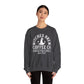 Wearing the Witches Brew Coffee Co. Sweatshirt - Stop in for a Spell! | Unisex Heavy Blend™ Crewneck Sweatshirt, featuring “Stop in for a spell—Since 1962” and a witch’s hat graphic, someone stands against a plain white background.