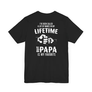The Papa Is My Favorite T-Shirt is a black unisex jersey tee made from soft Airlume cotton, featuring two fists bumping and the phrase: I’ve been called a lot of names in my lifetime but Papa is my favorite. Sustainably crafted.