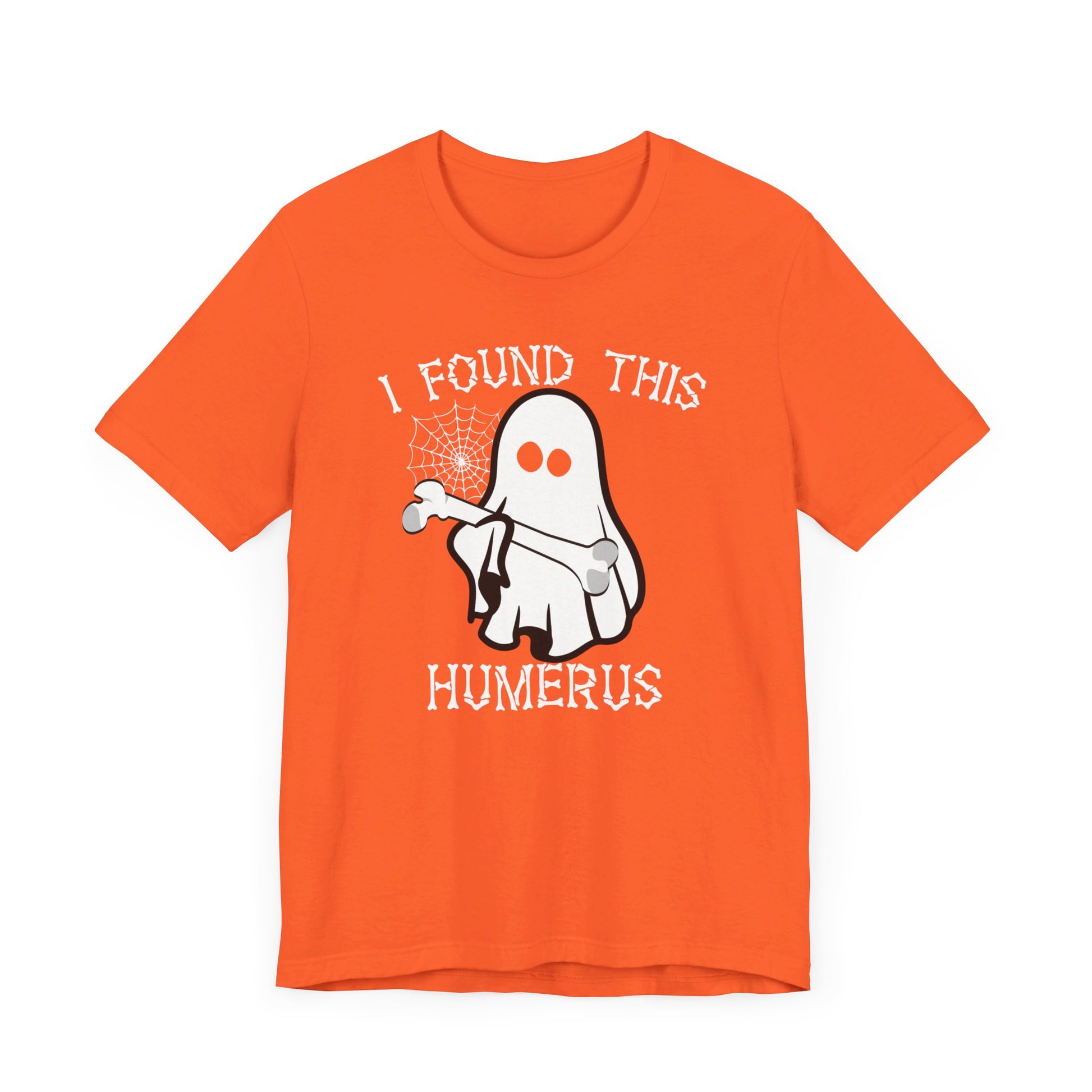 The I Found This Humerus - Funny Halloween Ghost T-Shirt features a playful ghost holding a bone and spider web with “I FOUND THIS HUMERUS” in spooky white letters—perfect for adding lighthearted Halloween flair to your look.