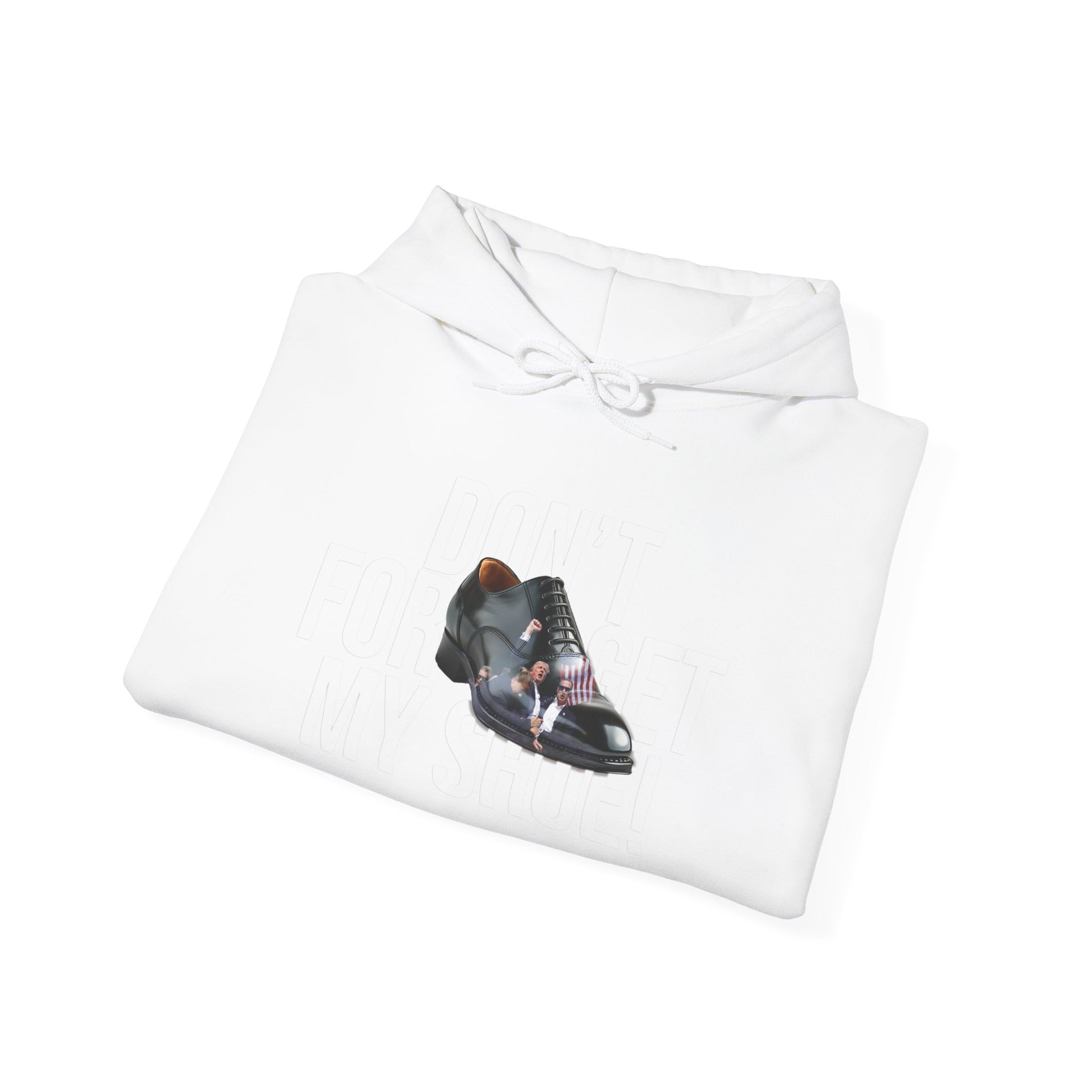 Unisex Heavy Blend™ Hooded Sweatshirt made from sustainable cotton-polyester blend. Displays a stylish polished black shoe and a tiny man figure polishing it. Faint background text adds an intriguing detail to this trendy piece.
