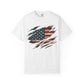 The “Torn Patriot” Distressed American Flag Comfort Colors Tee is a white shirt featuring a graphic of the American flag visible through claw mark-shaped rips on the front.