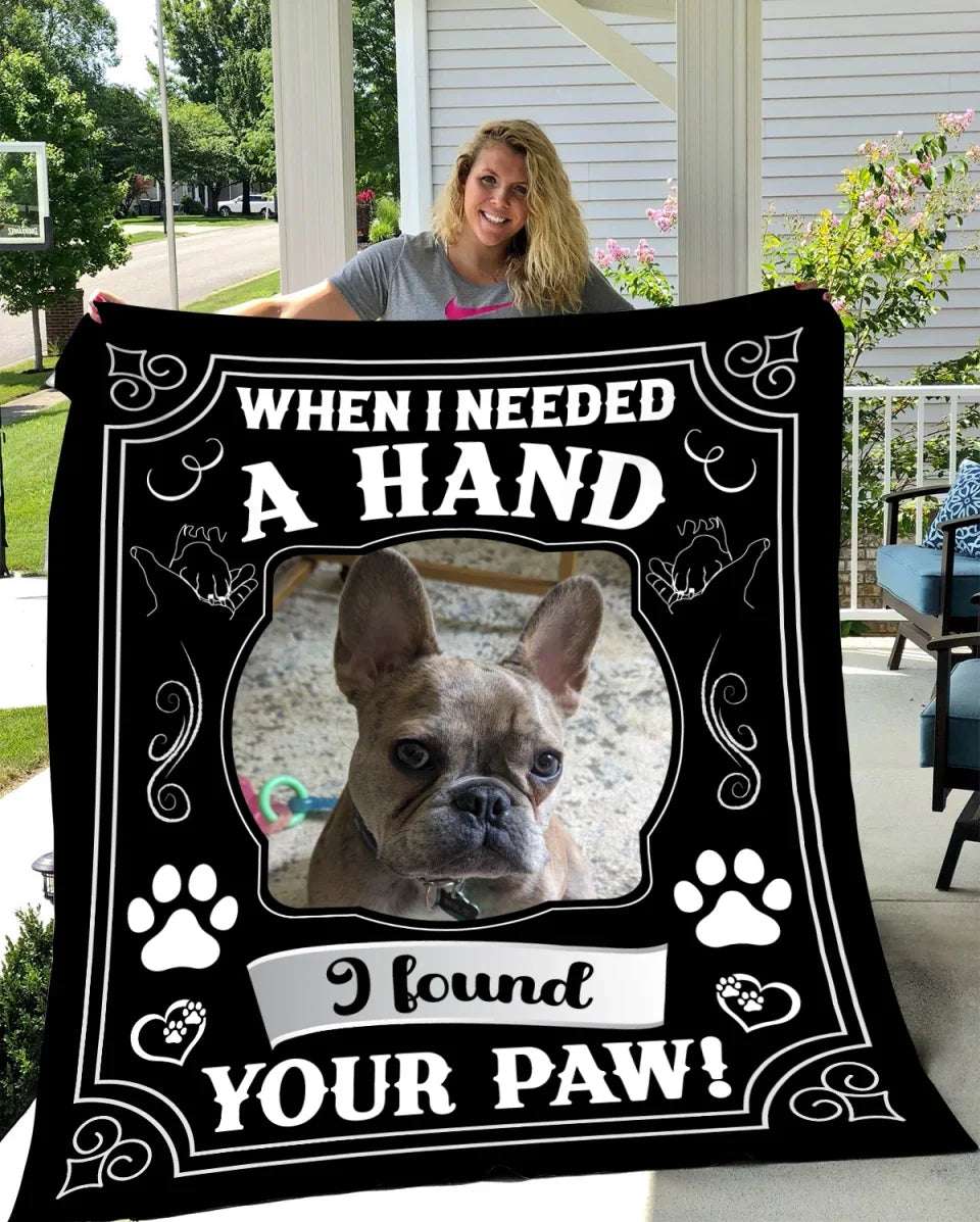 Custom pet blanket featuring a framed photo of a dog with the phrase "When I needed a hand, I found your paw!" in bold lettering, accented with paw prints.