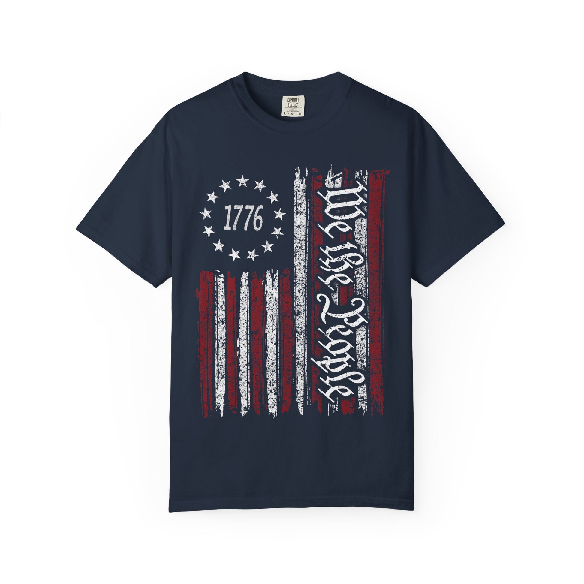 The We The People Distressed Flag Tee – Patriotic Comfort Colors 1717 Unisex Shirt features a navy blue, vintage American flag with 1776 in stars and We the People script on soft U.S. cotton.