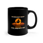 The On a Dark Desert Highway Halloween Witch Mug is a black 11oz ceramic coffee mug featuring a witch flying on a broomstick against an orange moon. Its perfect for coffee lovers with the enchanting text, On a dark desert highway, cool wind in my hair.