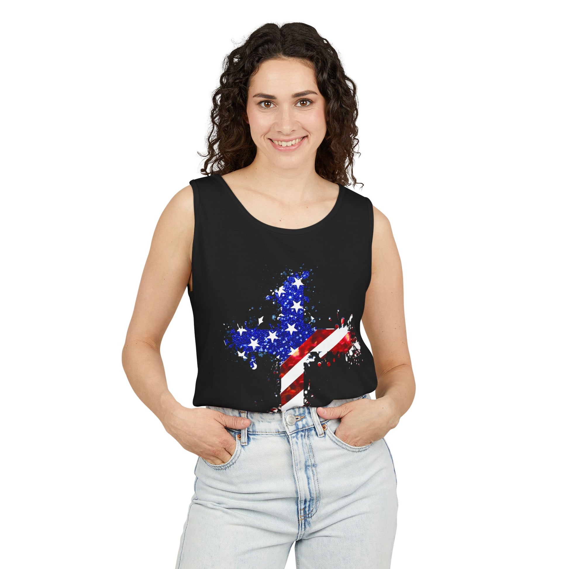 Smiling woman with curly hair wears the unisex Faith & Freedom Cross – Patriotic USA Tank Top, made from ring-spun US cotton and featuring a star and American flag cross design, paired with light blue jeans against a white background.