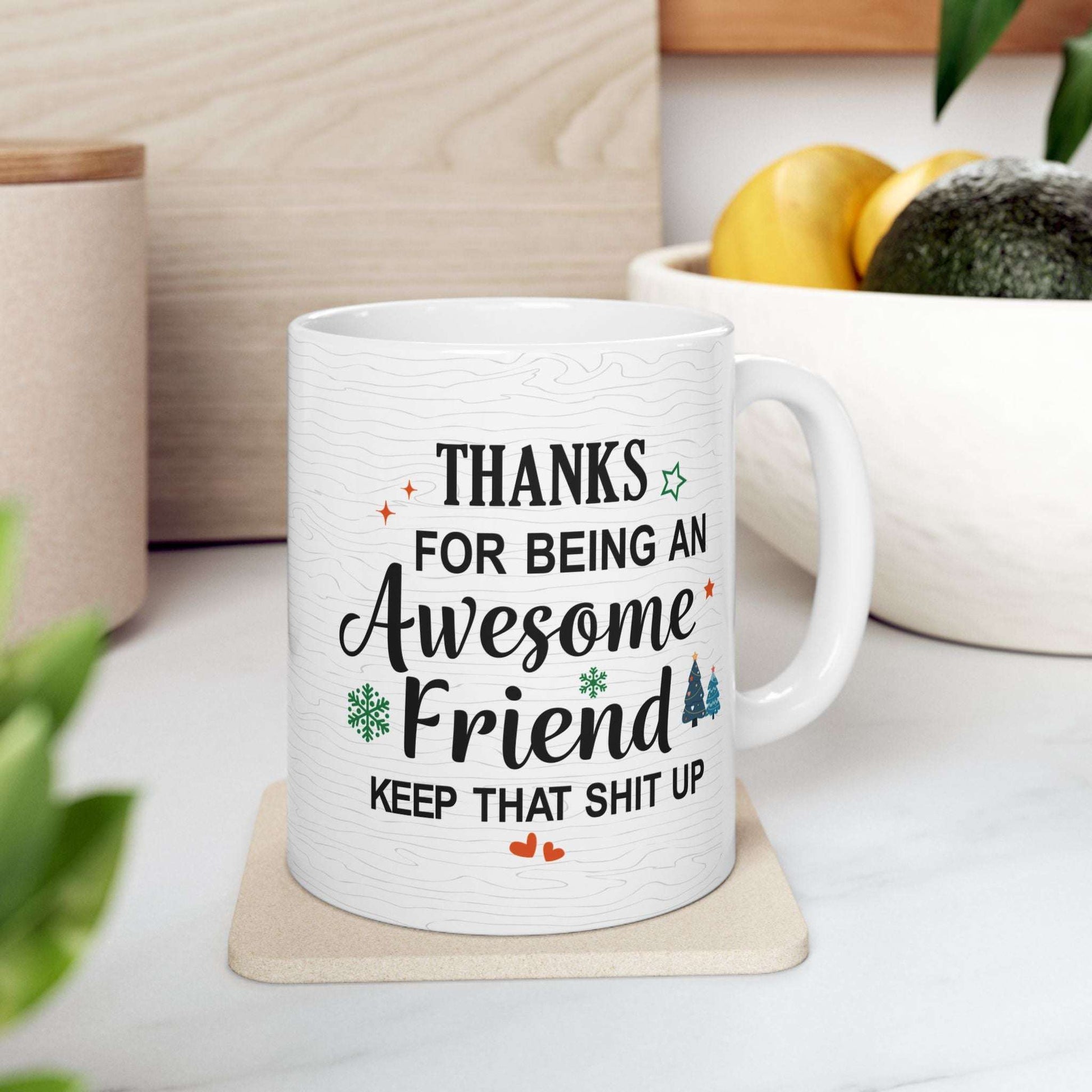 White ceramic mug with a humorous message thanking an awesome friend, decorated with festive elements like snowflakes and trees.