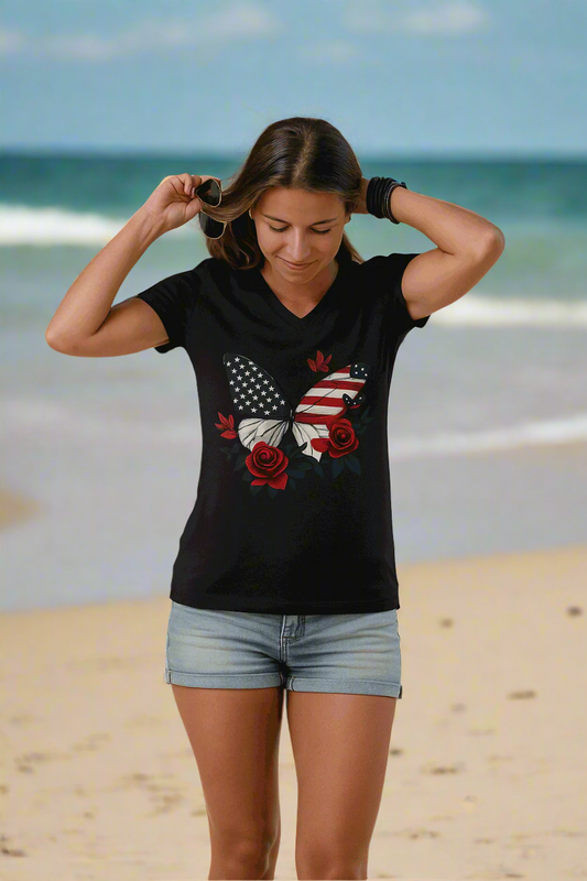 A woman, adjusting her hair outside, wears the American Beauty Butterfly Tee—a patriotic V-neck with roses and stars—paired with light denim shorts.