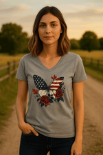 At sunset on a rural path, a woman with shoulder-length brown hair and a relaxed smile wears the American Beauty Butterfly Tee—a patriotic V-neck featuring an American flag butterfly, red roses, stars, and made from breathable cotton.