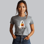 A woman in a gray Ghostly Pup Halloween T-Shirt - Adorable Trick or Treat Design! stands against a plain background, hands in her jeans pockets, smiling gently and capturing the essence of spooky fashion.