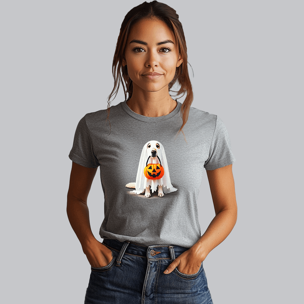 A woman in a gray Ghostly Pup Halloween T-Shirt - Adorable Trick or Treat Design! stands against a plain background, hands in her jeans pockets, smiling gently and capturing the essence of spooky fashion.