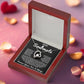 Silver heart pendant necklace with a sparkling crystal, displayed in a wooden gift box with a romantic message for a soulmate, surrounded by rose petals.