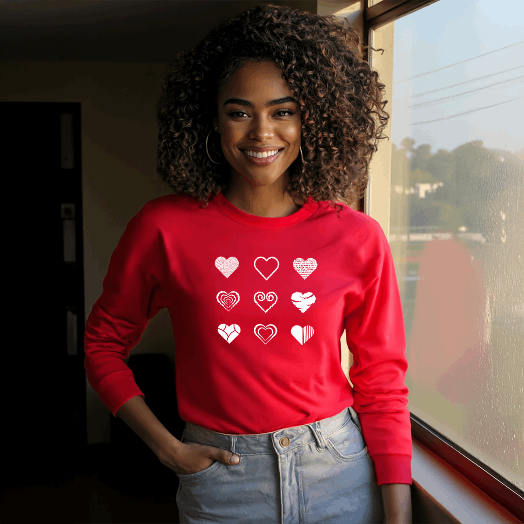 Woman wearing a red sweatshirt featuring a minimalist heart design with various artistic heart patterns in white.