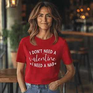 Woman wearing a red t-shirt with the funny Valentine's Day quote, "I don’t need a Valentine, I need a nap," in white script.