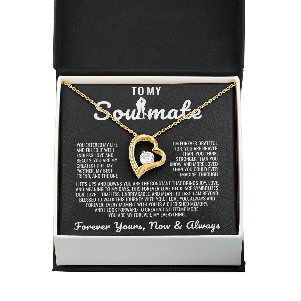 Gold heart pendant necklace with a sparkling crystal, displayed in a wooden gift box with a romantic message for a soulmate, surrounded by rose petals.