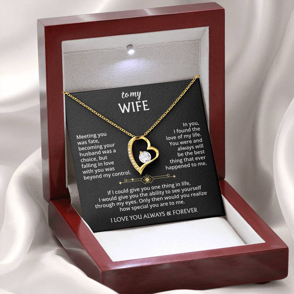 The To My Wife – Forever Love Necklace with Message of Fate and Devotion features a gold heart-shaped pendant with a central stone, presented in a red box lined with white satin. An affectionate message is printed in white inside the lid—an ideal anniversary gift.