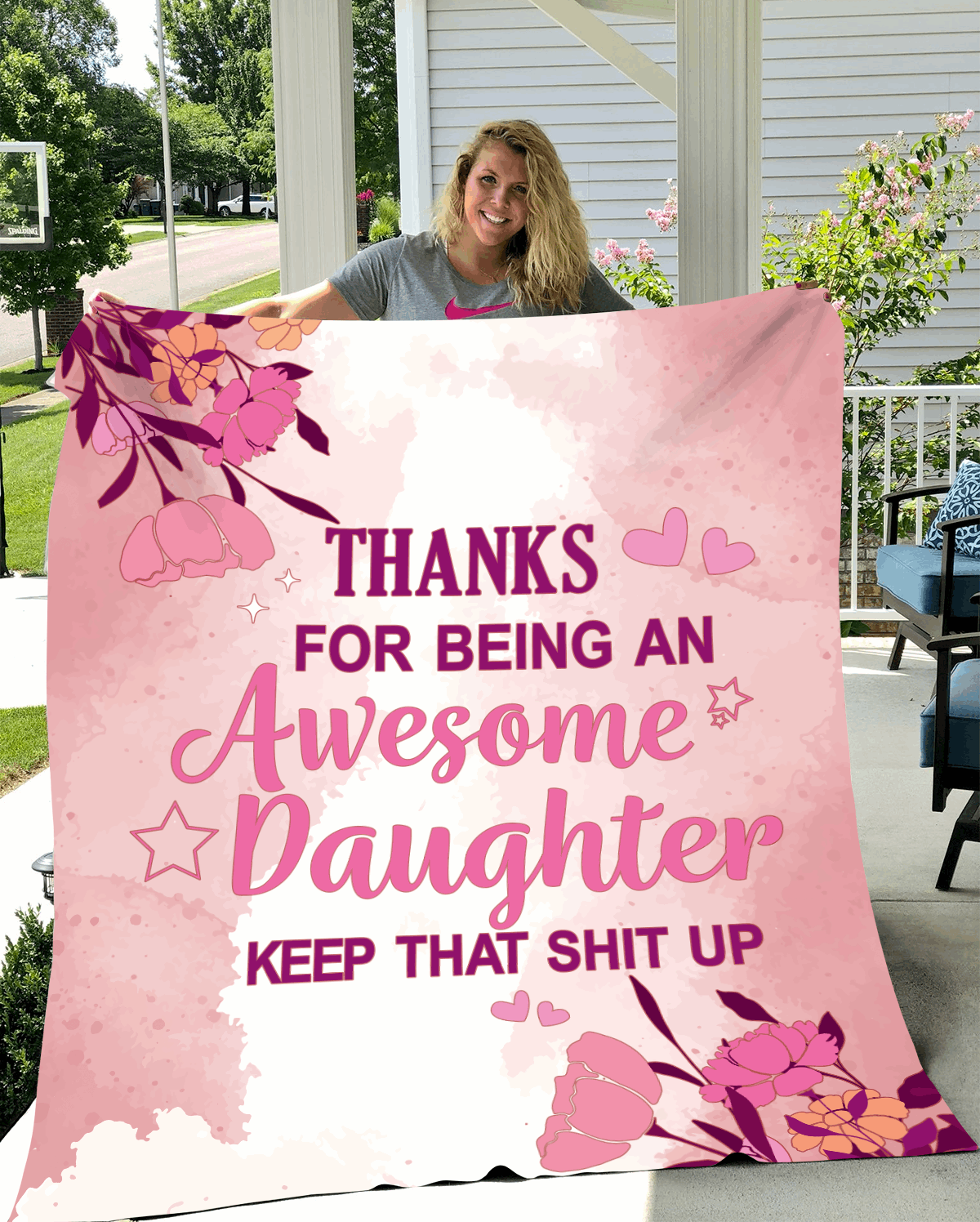 Pink floral-themed blanket with a bold, humorous message thanking an awesome daughter, held by a smiling woman outdoors.