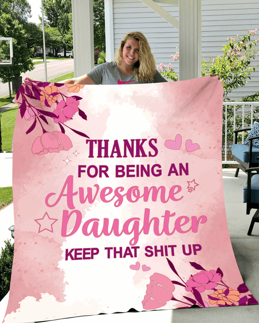 Pink floral-themed blanket with a bold, humorous message thanking an awesome daughter, held by a smiling woman outdoors.