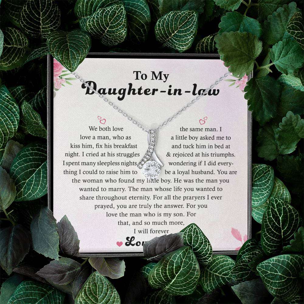 The To My Daughter-in-Law - Alluring Beauty necklace features an infinity pendant with a 14k white gold finish on a message card titled To My Daughter-in-law, adorned with green leaves and expressing love and family sentiments.