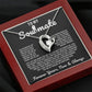 Silver heart pendant necklace with a sparkling crystal, displayed in a wooden gift box with a romantic message for a soulmate, surrounded by rose petals.
