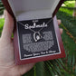 Silver heart pendant necklace with a sparkling crystal, displayed in a wooden gift box with a romantic message for a soulmate, surrounded by rose petals.