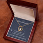 The To My Granddaughter - Forever Love Necklace with Heartfelt Message Card features a gold heart-shaped pendant and CZ crystal, beautifully displayed in an open dark wood box. Inside, a message reads: To My Granddaughter. I love you to the moon and back, with moon and star illustrations on brown leather.