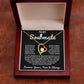 Gold heart pendant necklace with a sparkling crystal, displayed in a wooden gift box with a romantic message for a soulmate, surrounded by rose petals.