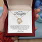 A hand presents an open box displaying the To My Daughter: Forever Connected Love Knot Necklace, finished in white gold with sparkling cubic zirconia. Inside, a heartfelt card reads: “The proudest moment for me is telling others you’re my daughter. Love, Dad.”.
