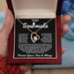Gold heart pendant necklace with a sparkling crystal, displayed in a wooden gift box with a romantic message for a soulmate, surrounded by rose petals.