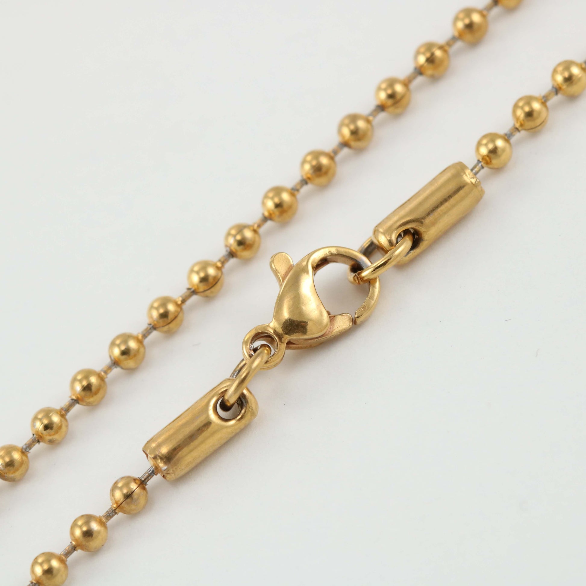 Close-up of the Replacement Attachment, a gold ball chain necklace with a lobster clasp, displayed on a white background.