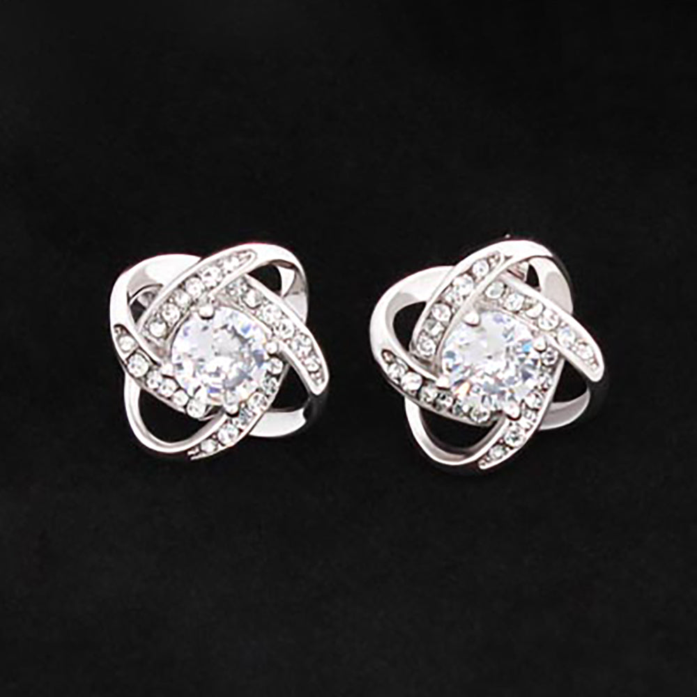 A Replacement Attachment in silver with an intricate, swirling design, featuring sparkling clear center stones and smaller accents—an elegant accessory set against a black background.