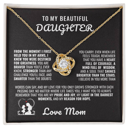 Gold love knot necklace with a sparkling crystal, presented in a gift box with a heartfelt message from a mother to her daughter