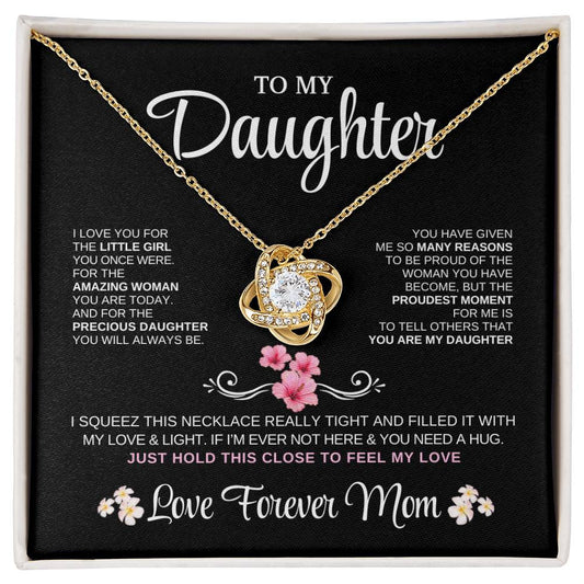 Elegant silver love knot necklace with a sparkling crystal, displayed in a black gift box featuring a heartfelt message from a mother to her daughter.