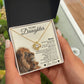 A person holds an open To My Daughter – Love Knot Necklace with Lion & Cub Message Card, featuring a heartfelt message and pendant—an ideal gift for daughters.