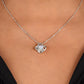 A close-up of a person wearing the To My Daughter – Love Knot Necklace with a sparkling pendant, set against bare skin and a black V-neck top, shown with the Lion & Cub Message Card.