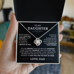A hand holds an open box displaying the To My Daughter - Love Knot Necklace in 14k White Gold. Inside the lid is a heartfelt message from a father, making it the ideal gift to express love and encouragement to a daughter.