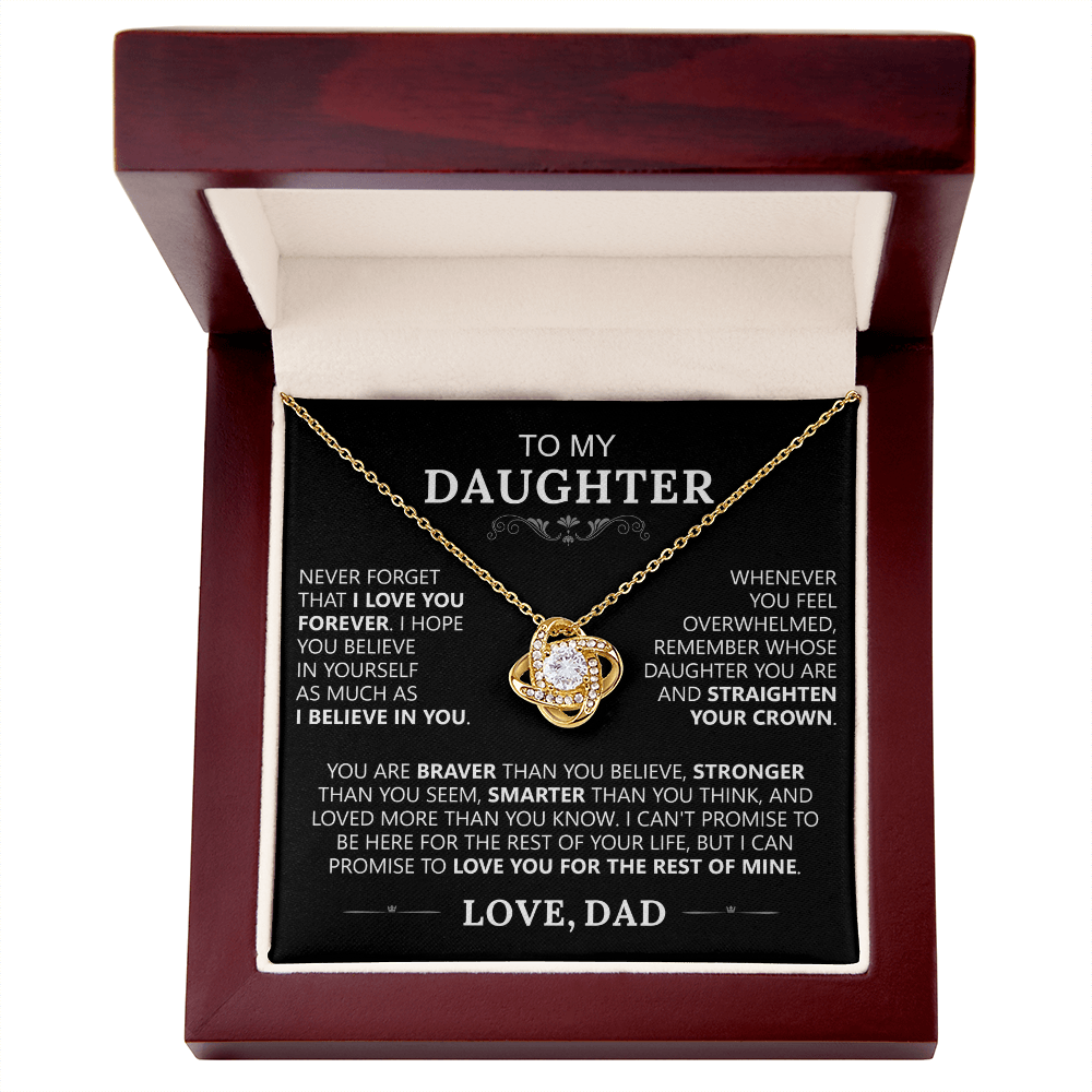 The To My Daughter - Love Knot Necklace features a shiny pendant in a wooden jewelry box. Inside, a heartfelt message from dad celebrates your unbreakable bond, love, and strength—a perfect father-daughter gift.