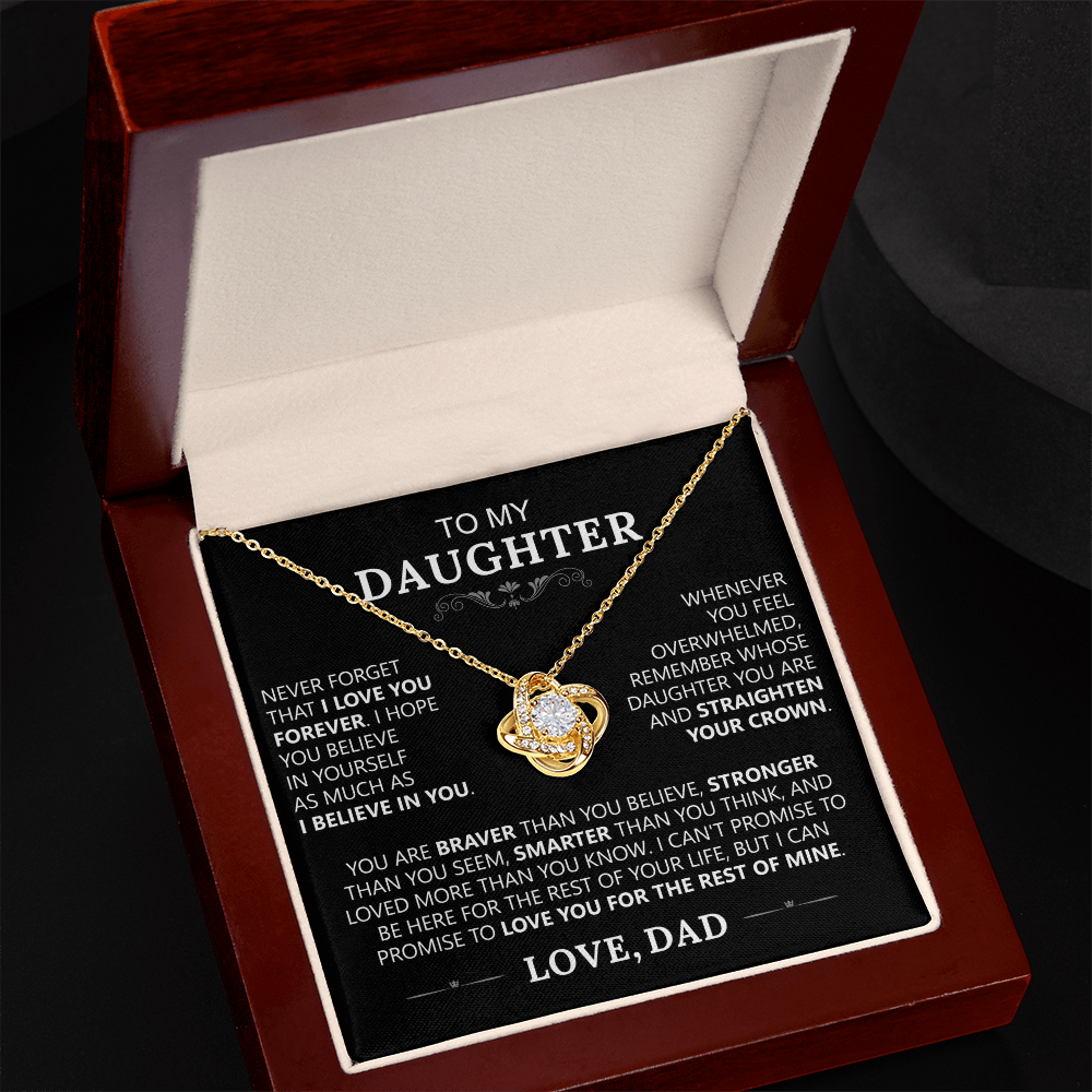 The To My Daughter - Love Knot Necklace features a heart-shaped pendant in a wooden gift box with a heartfelt message from father to daughter, celebrating their unbreakable bond and offering love and encouragement for her future.